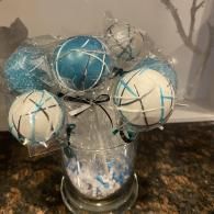 Blue and white decorative balls in a glass vase on a countertop