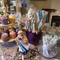 Candy and dessert display with cupcakes, lollipops, and pastel treats on a decorated table
