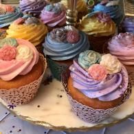 Assorted cupcakes with pastel-colored frosting on a tray