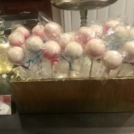 Tray of pink and white cotton candy bags in a clear display case