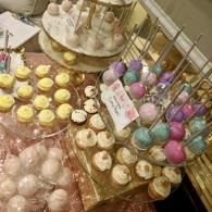 Pastel bath bombs and bath salts arranged in trays at a market stall