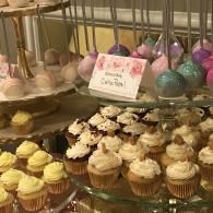 Cupcakes on a dessert table with pastel lollipops and colorful Easter egg decorations