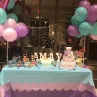Pastel balloon birthday table with a “Maya” cake and decorations