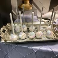 Tray of white cake pops with pearl-studded sticks on a silver serving platter
