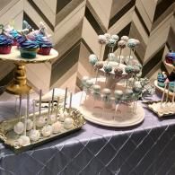Dessert display with pastel cake pops and sweets on a decorated buffet table