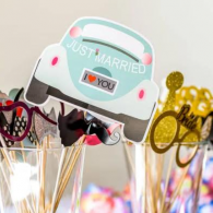 Wedding photo props with a “Just Married” car sign and “I ♥ You” sign on sticks