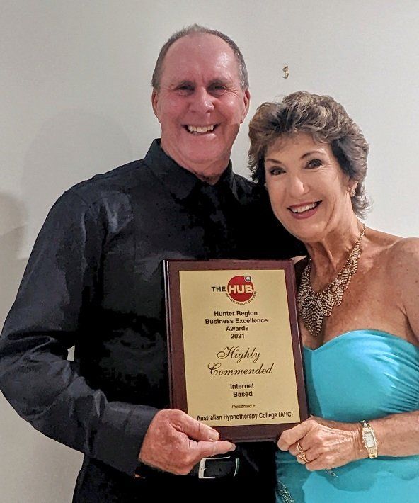 A Man and Woman Holding a Plaque that says Highly Recommended