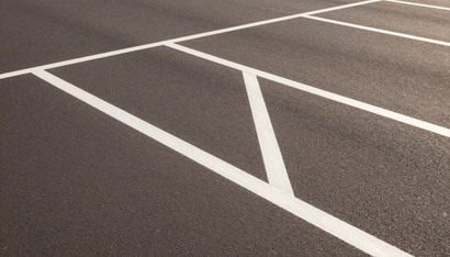 White painted lines marking parking spaces on a dark asphalt lot.