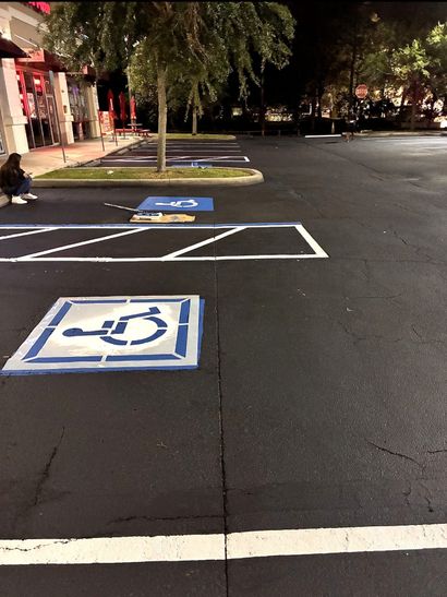 Blue wheelchair accessibility symbol on a sidewalk tile.