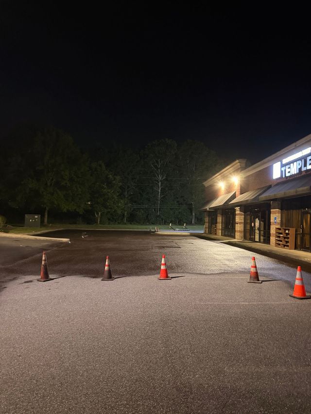Empty parking lot with a white pickup truck under a bright blue sky