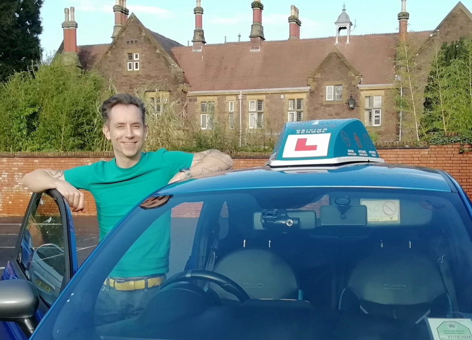 a-class driving school instructor stands by his car ready to teach a lesson
