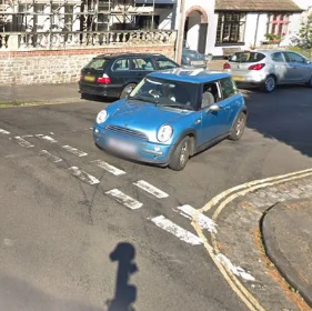 turning into a narrow road with parked up cars
