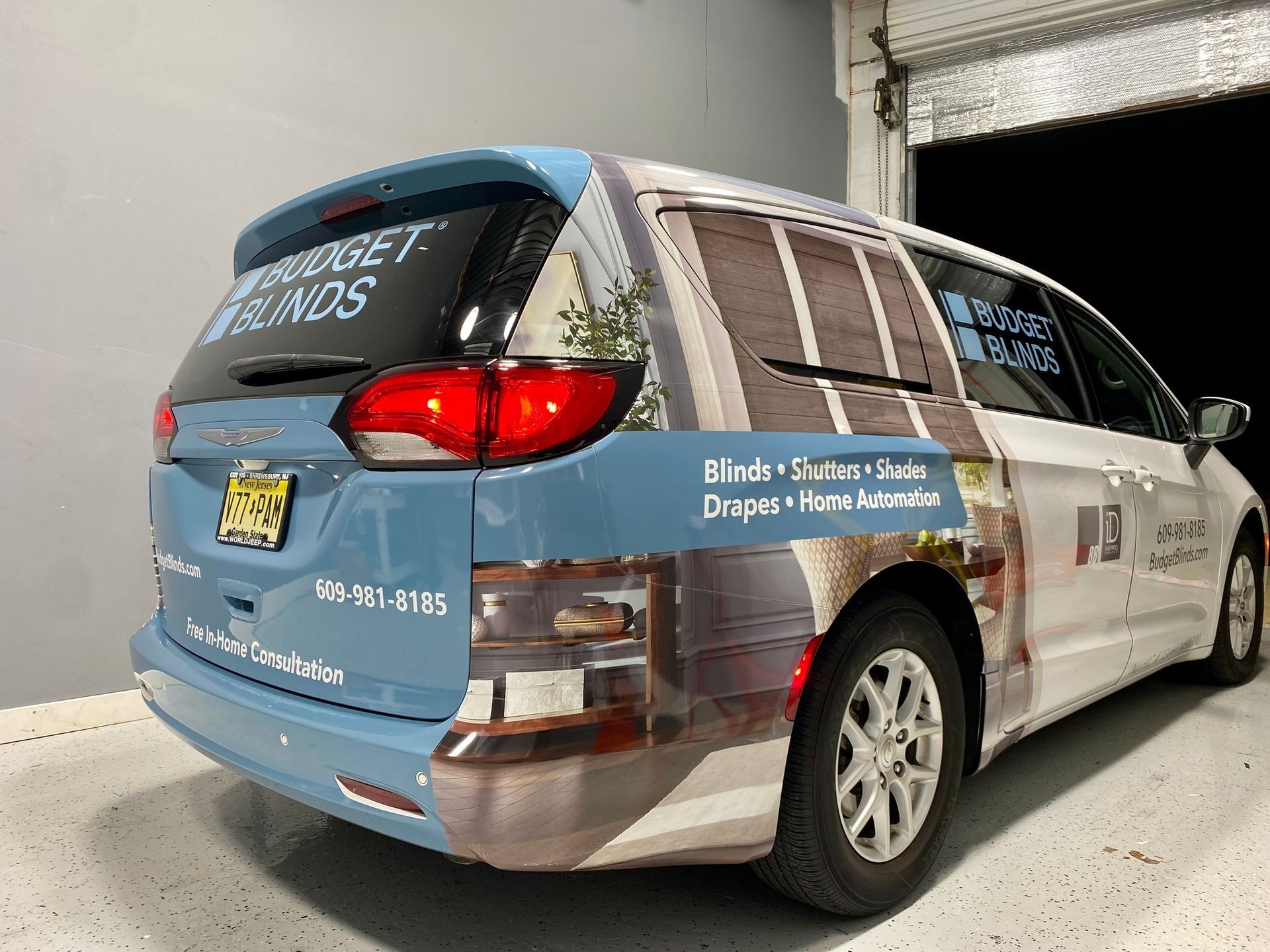 Blue-and-white branded minivan with “Dignity Home” text, parked indoors in a garage.