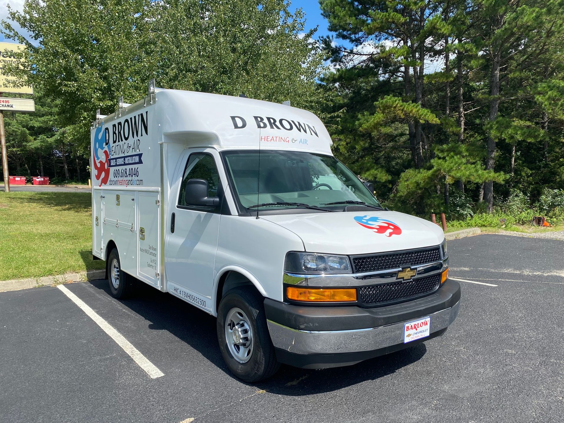 White box truck parked in a lot, with company lettering on the side and hood.