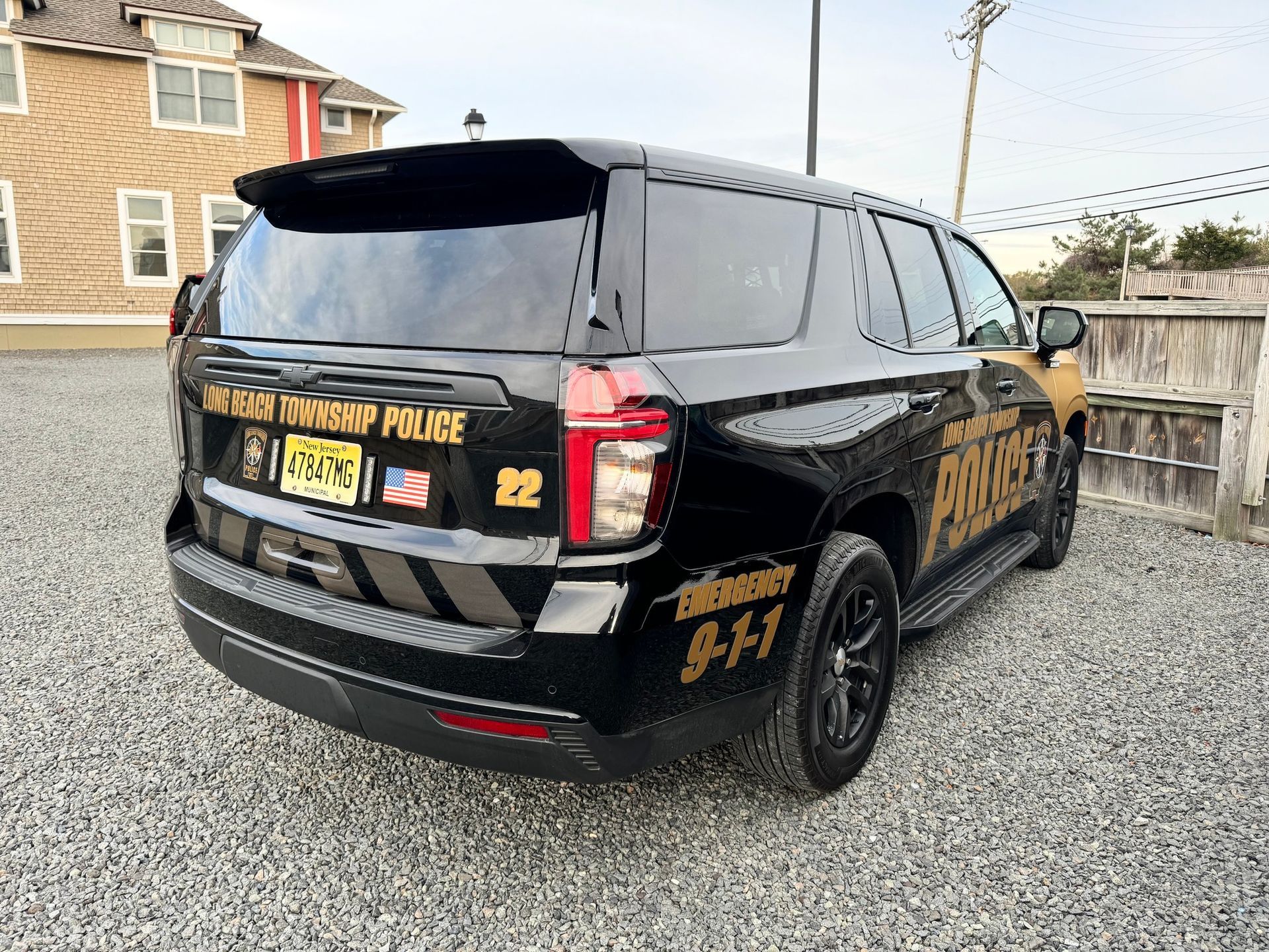 Black Mercedes police SUV with gold lettering parked on a street near houses