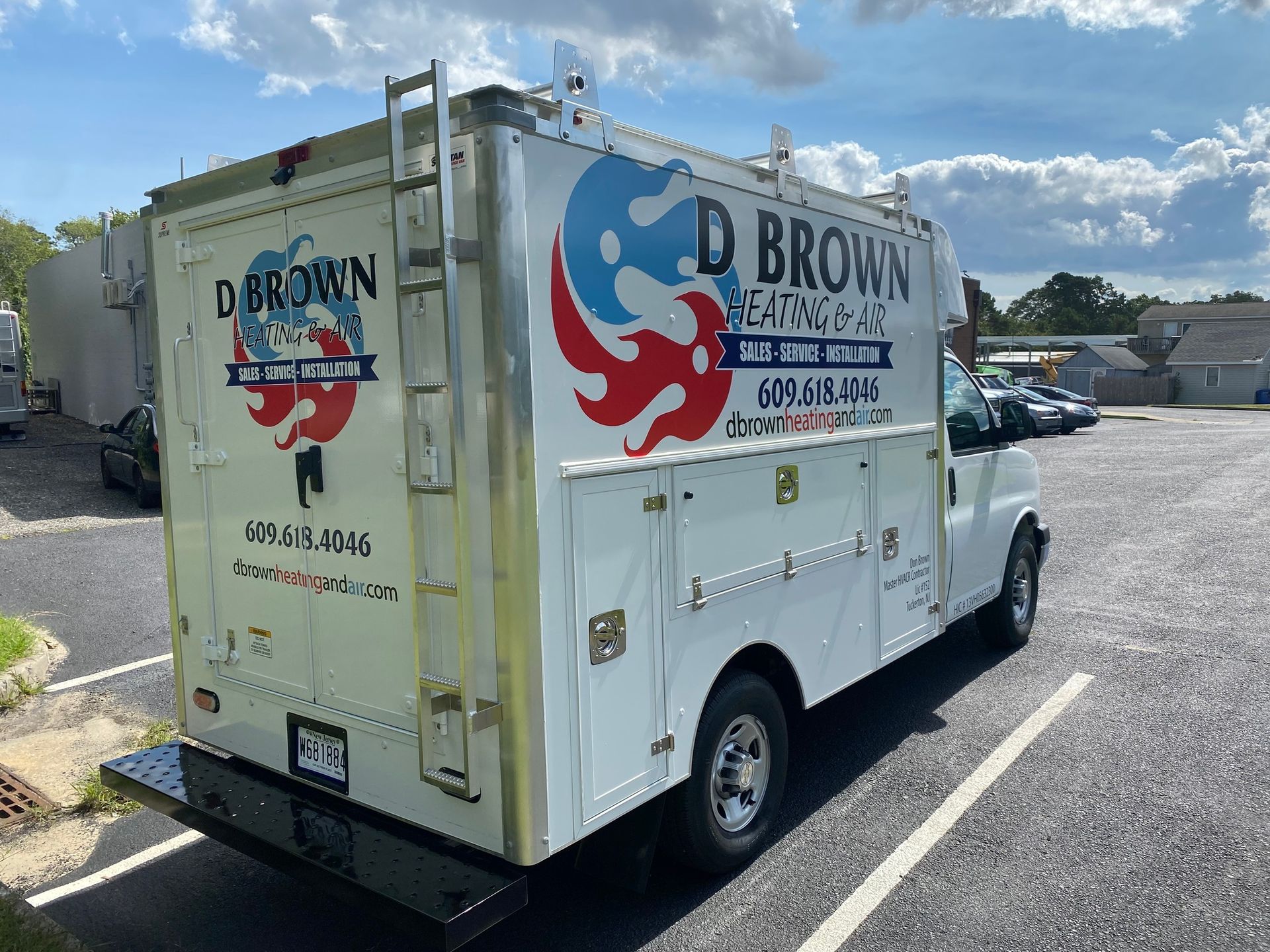 White service truck with D. Brown Plumbing logo parked in a lot on a sunny day