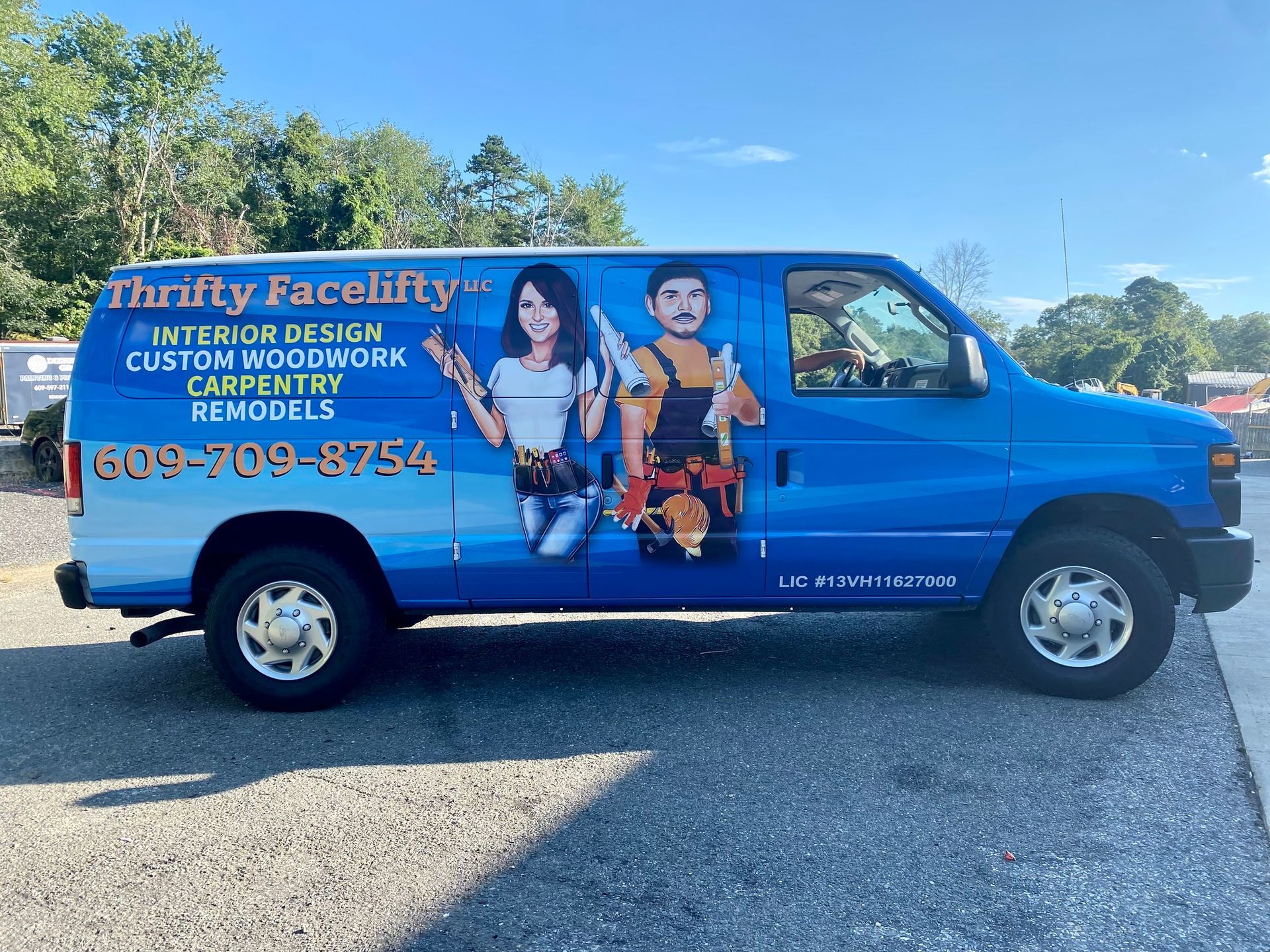 Blue custom-window tinting van with service advertising and cartoon workers parked outdoors.