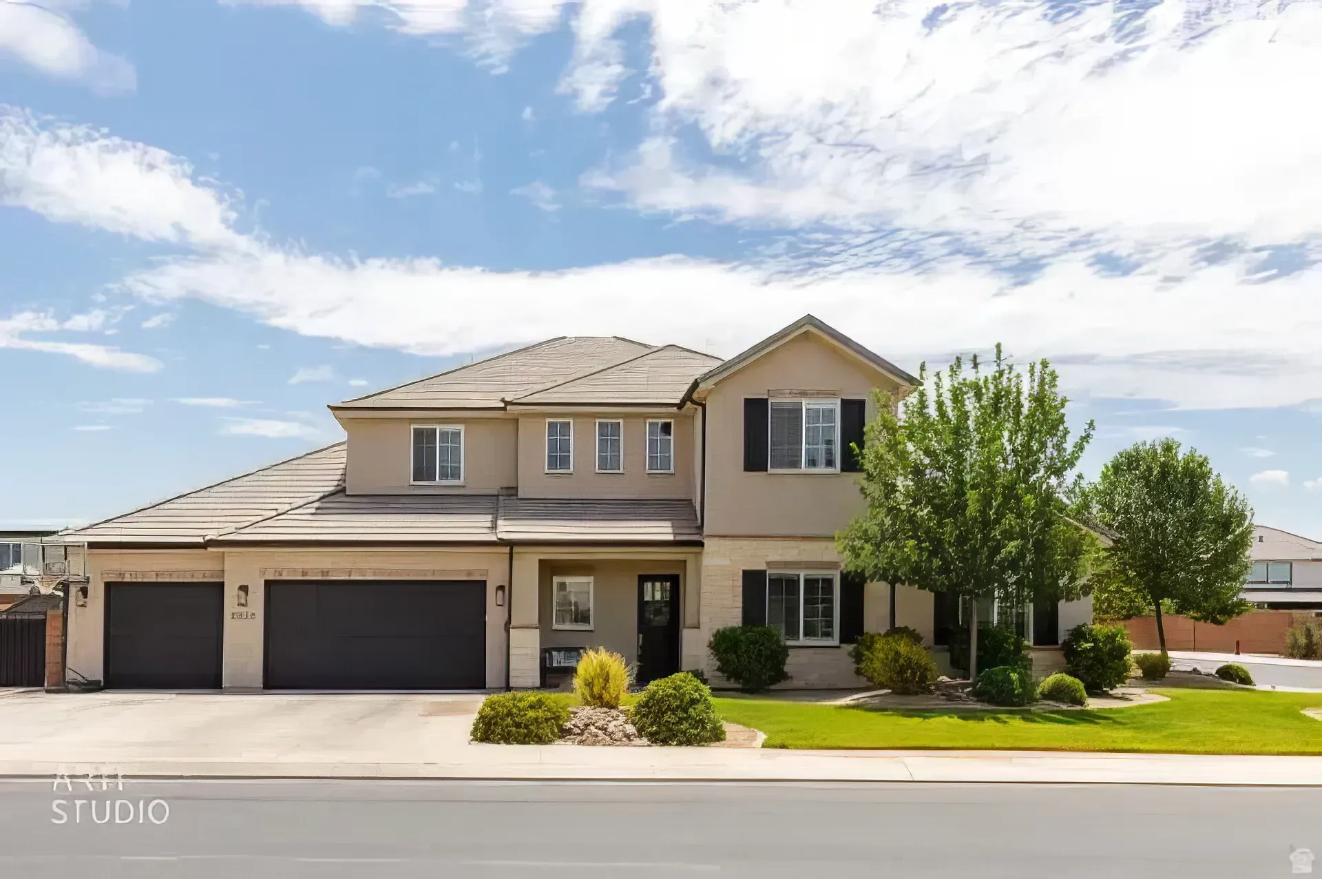 Two-story beige suburban house with a three-car garage and a manicured front lawn under a blue sky