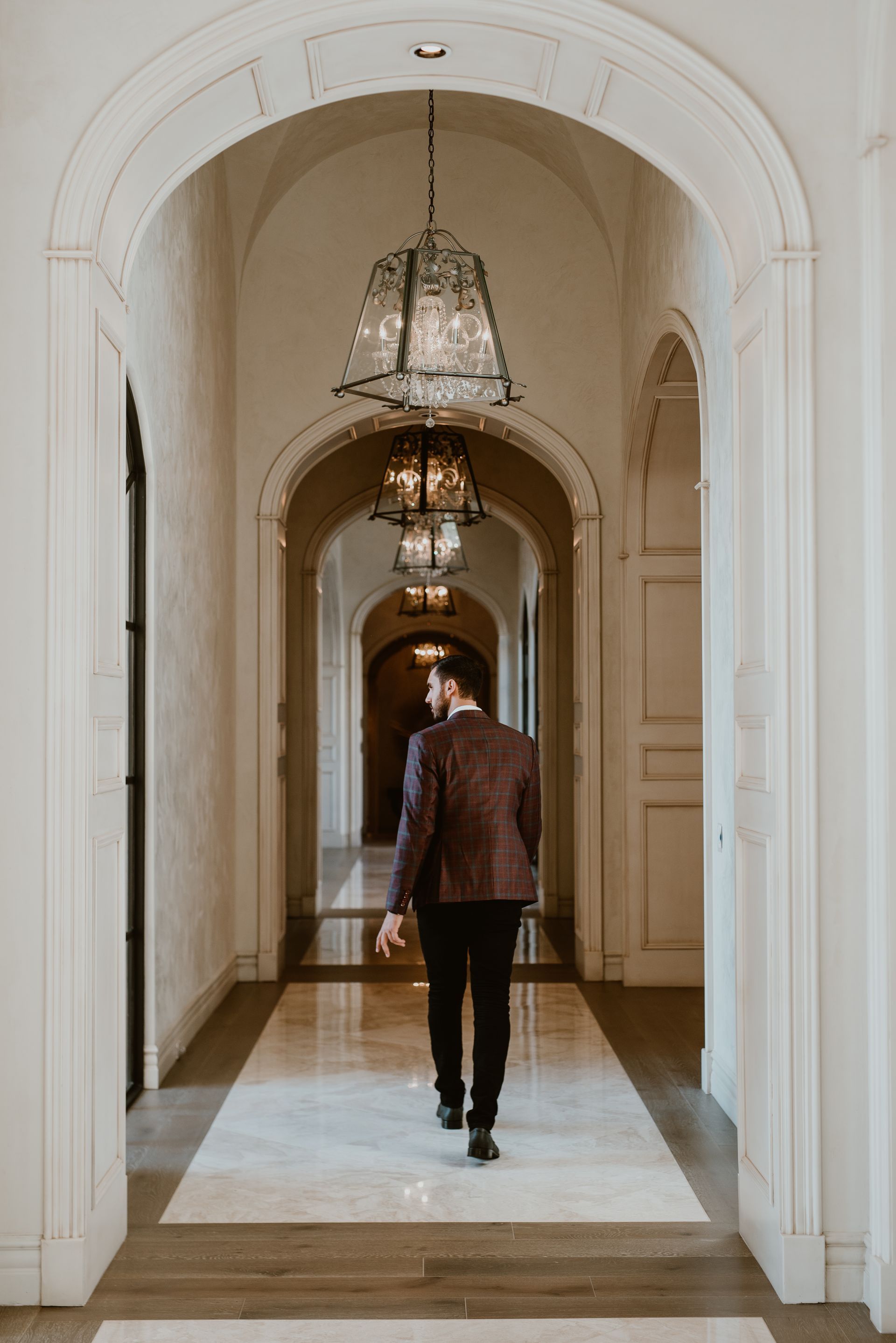 A man in a suit is walking down a hallway.