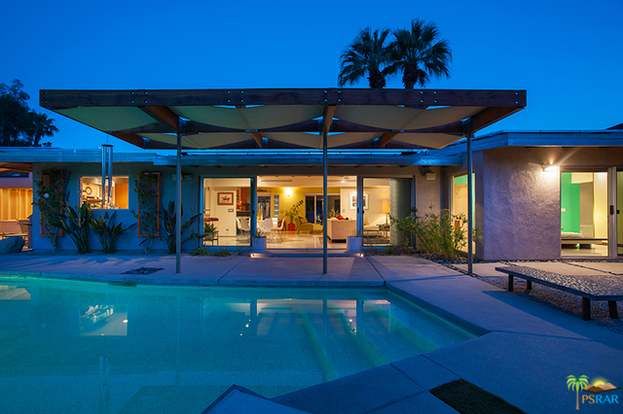 A house with a swimming pool in front of it