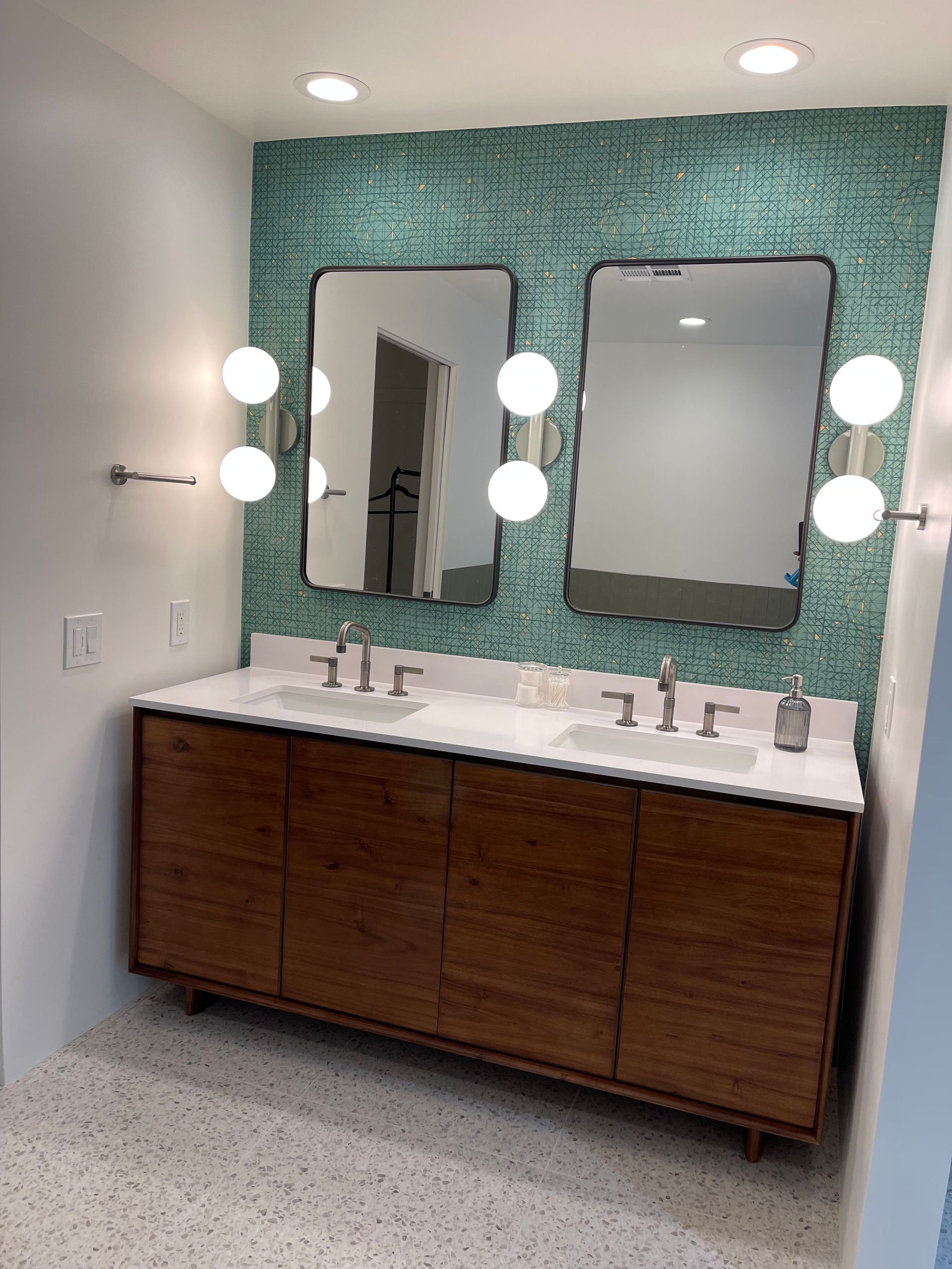 A bathroom with two sinks and two mirrors.