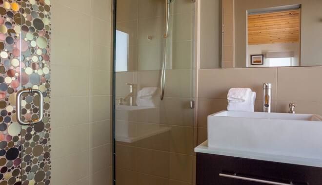 A bathroom with a sink and a walk in shower.