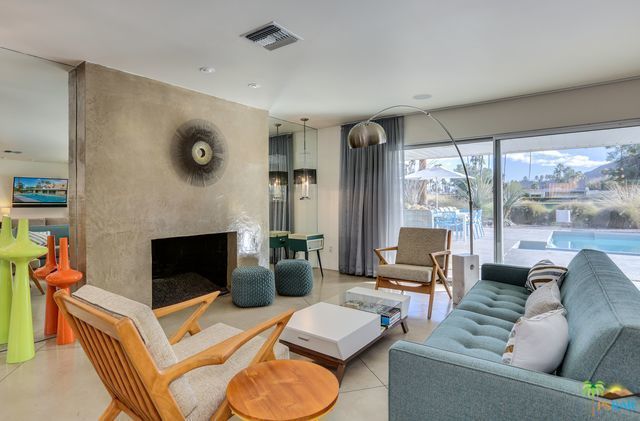A living room with a couch , chairs , coffee table and fireplace.
