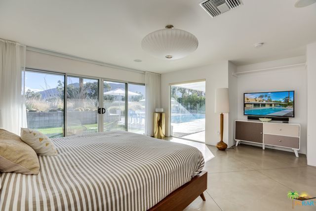 A bedroom with a large bed and a flat screen tv.