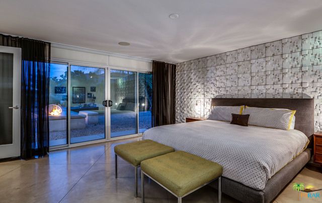 A bedroom with a large bed and sliding glass doors.