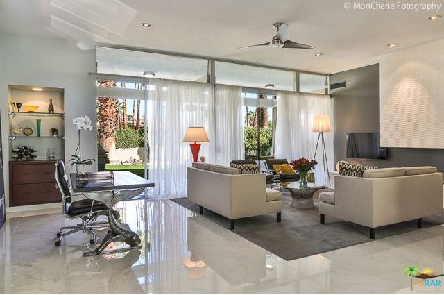 A living room with white furniture and a desk