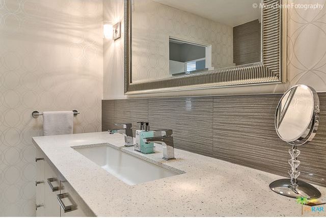 A bathroom with a large mirror and a sink