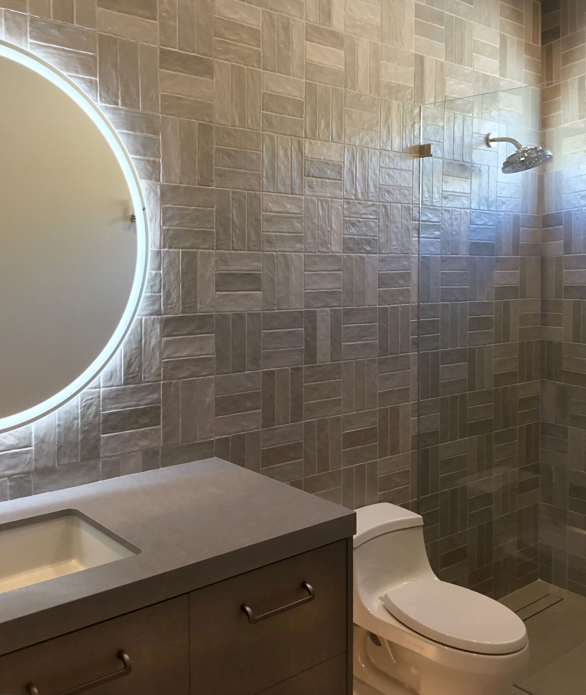 A bathroom with a toilet , sink , mirror and shower.