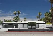 A model of a house with palm trees in front of it.