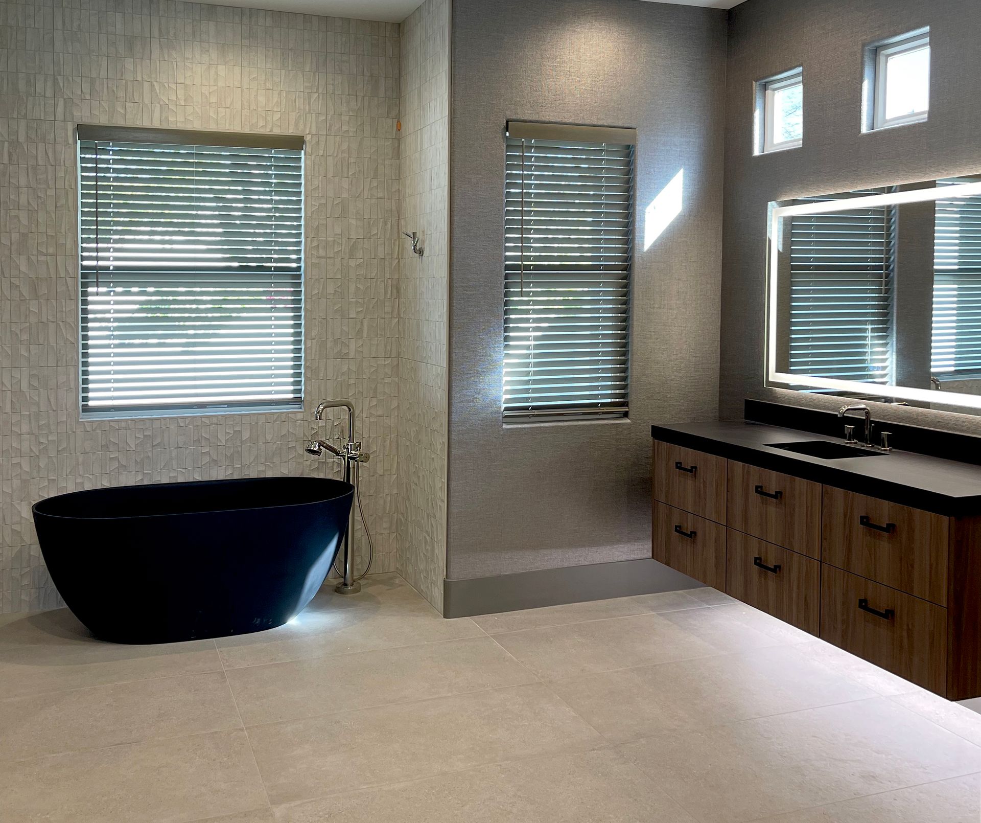 A bathroom with a black tub and a sink