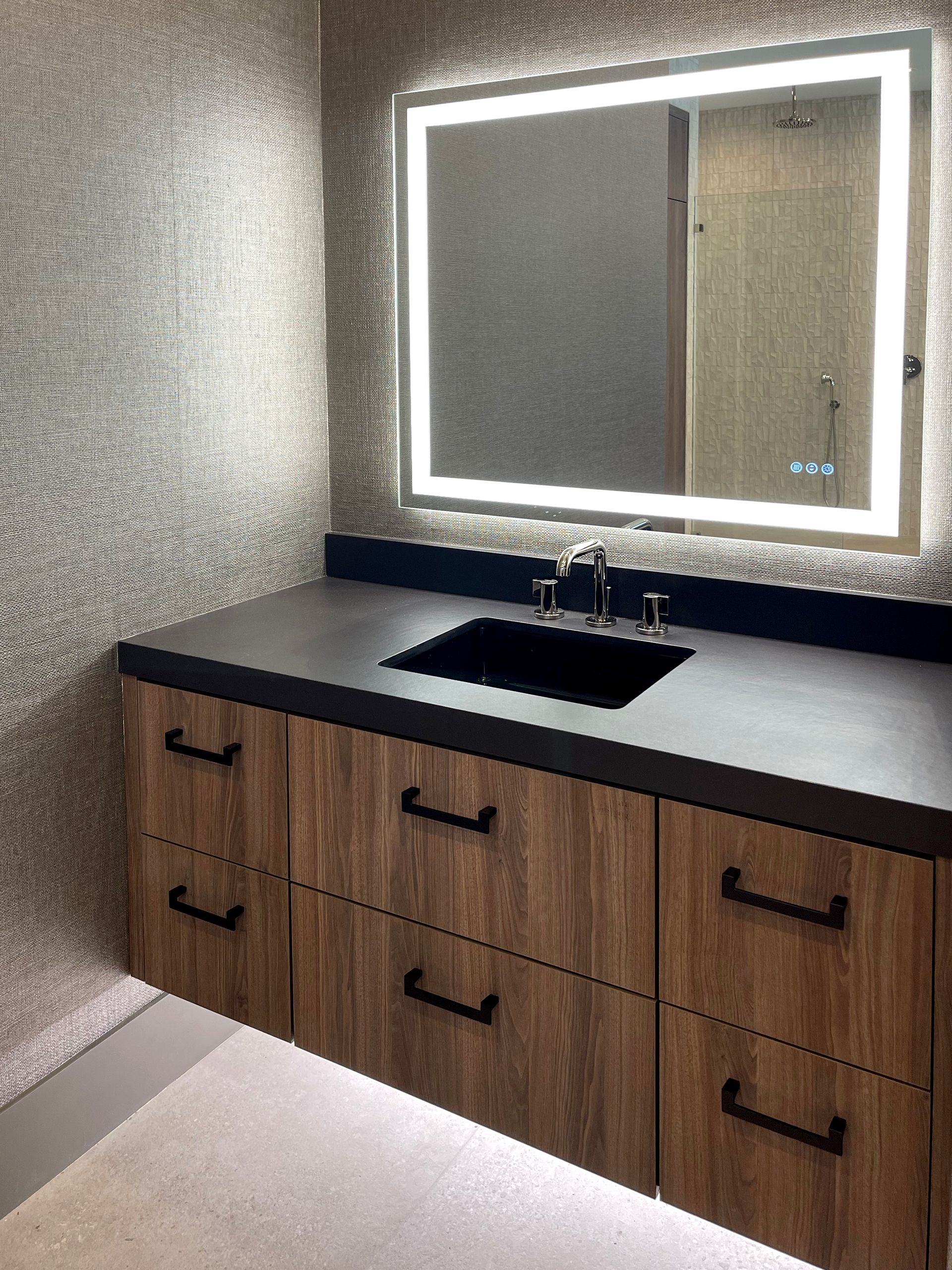A bathroom with a sink , mirror and drawers