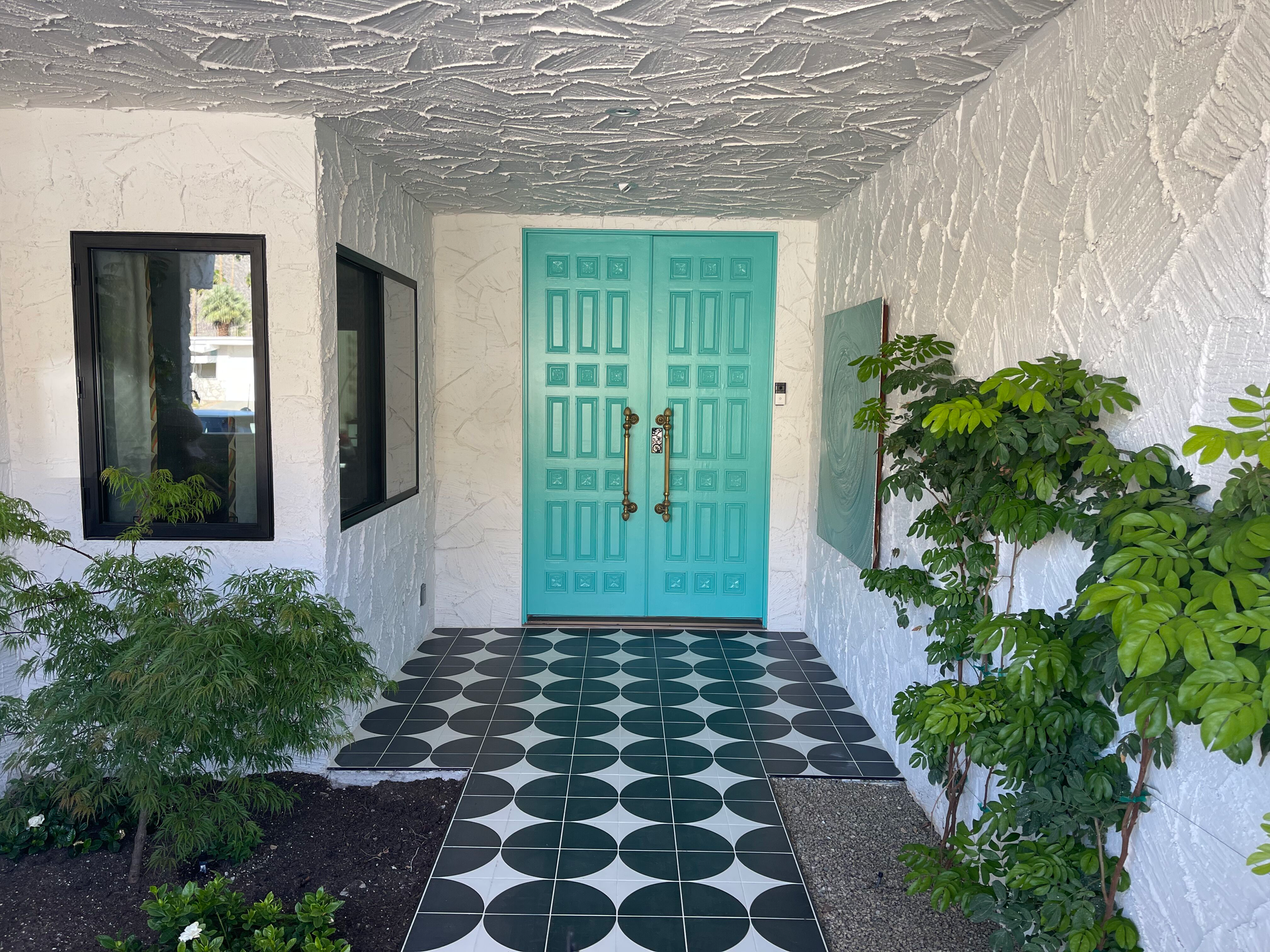 A white building with a blue door and a black and white checkered floor