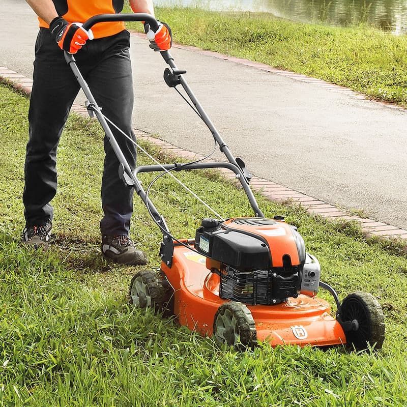 A Person Is Using A Husqvarna Lawn Mower To Cut The Grass — Mid Coast Mowers In Taree, NSW