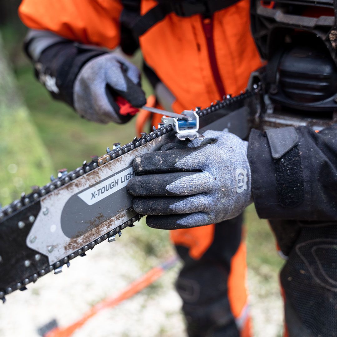 A Person Is Holding A Chainsaw That Says X-touch On It — Mid Coast Mowers In Taree, NSW