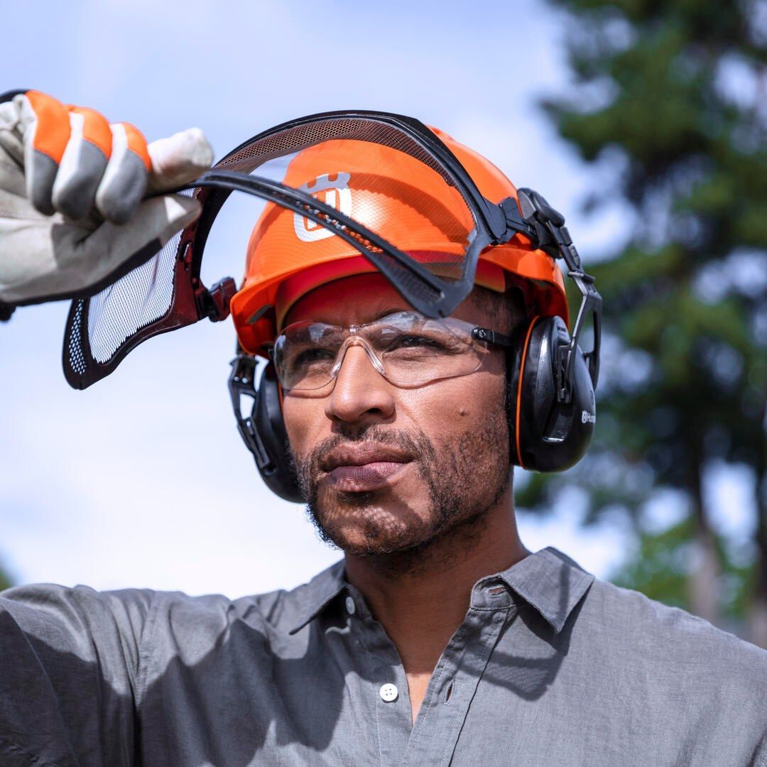 A Man Wearing An Orange Hard Hat And Headphones — Mid Coast Mowers In Taree, NSW