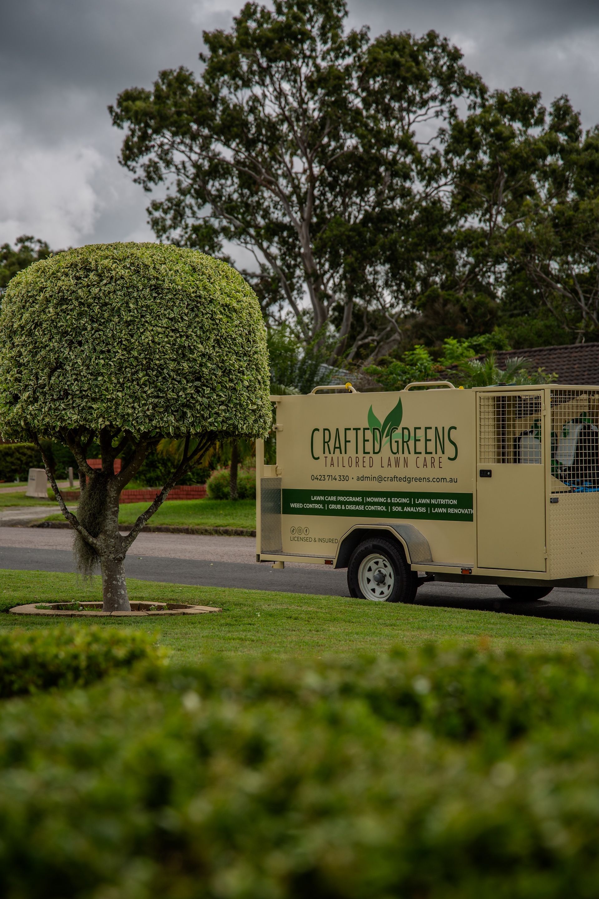 Well-manicured Green Lawn Bordering a Sidewalk and a Flower Bed With Red Blooms — Mow & Mulch Lawn & Garden Maintenance In Corlette, NSW