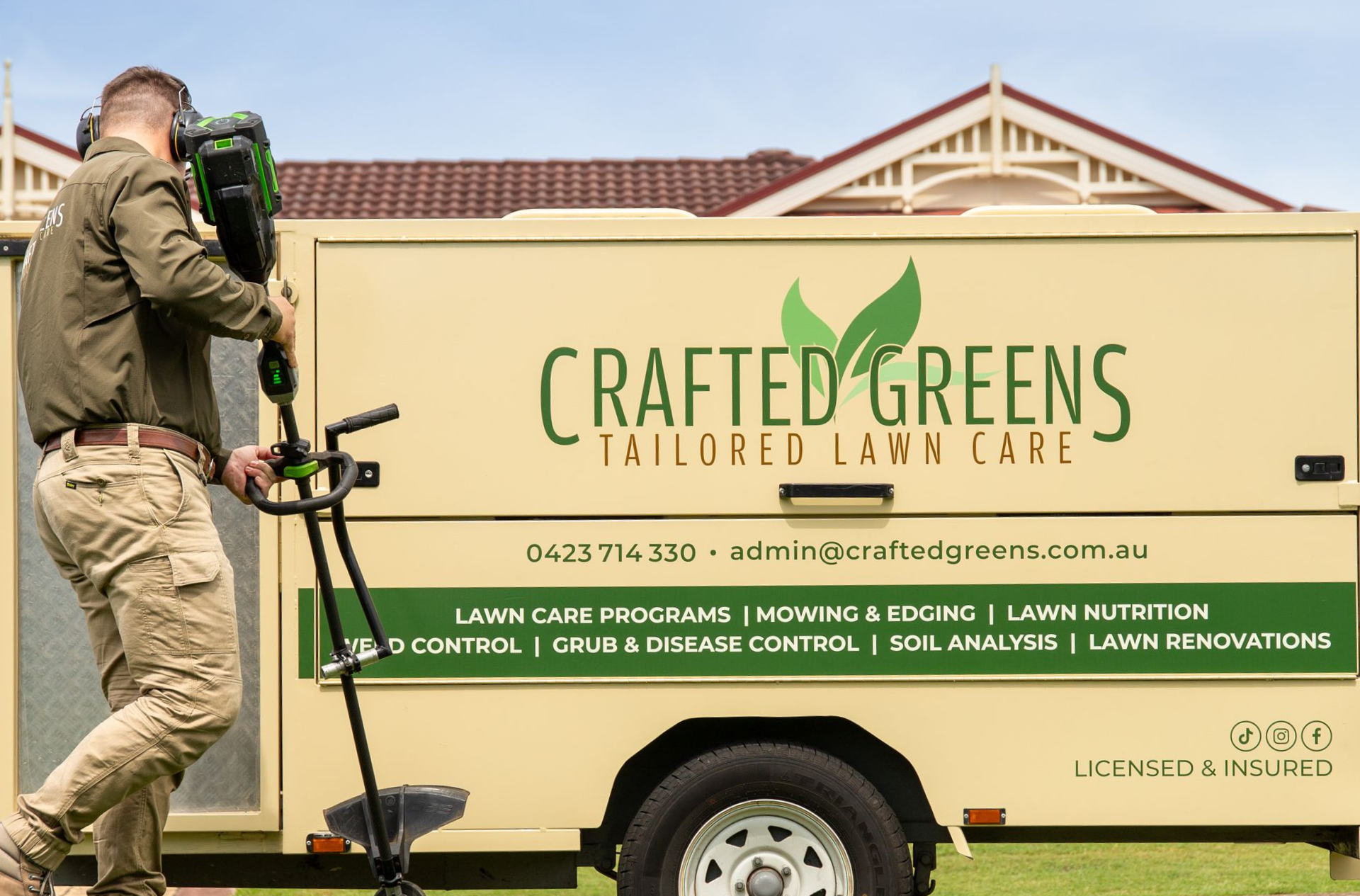 Man Using Lawn Trimmer Near a Beige Trailer Set in Front of a House — Mow & Mulch Lawn & Garden Maintenance In Salamander Bay, NSW