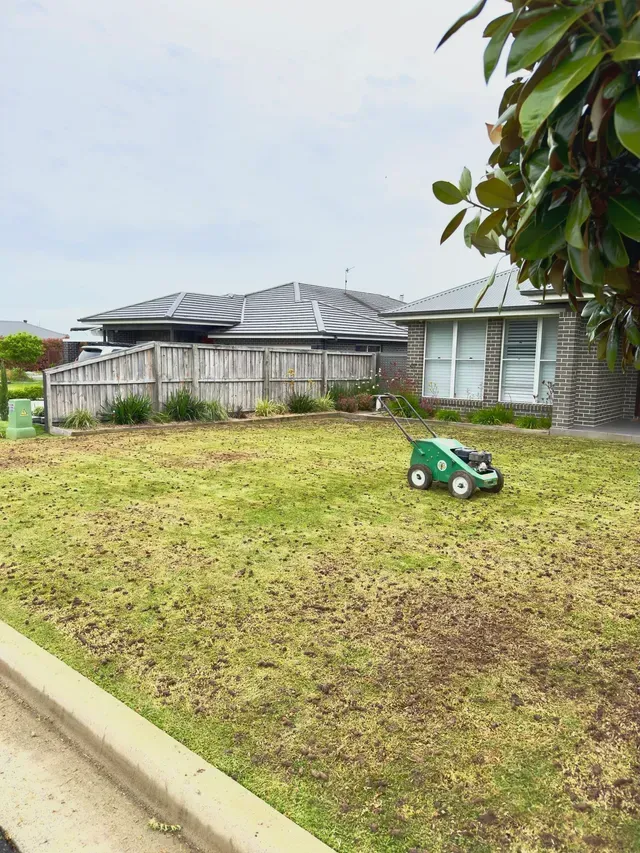Person spraying lawn with a trailer labeled 