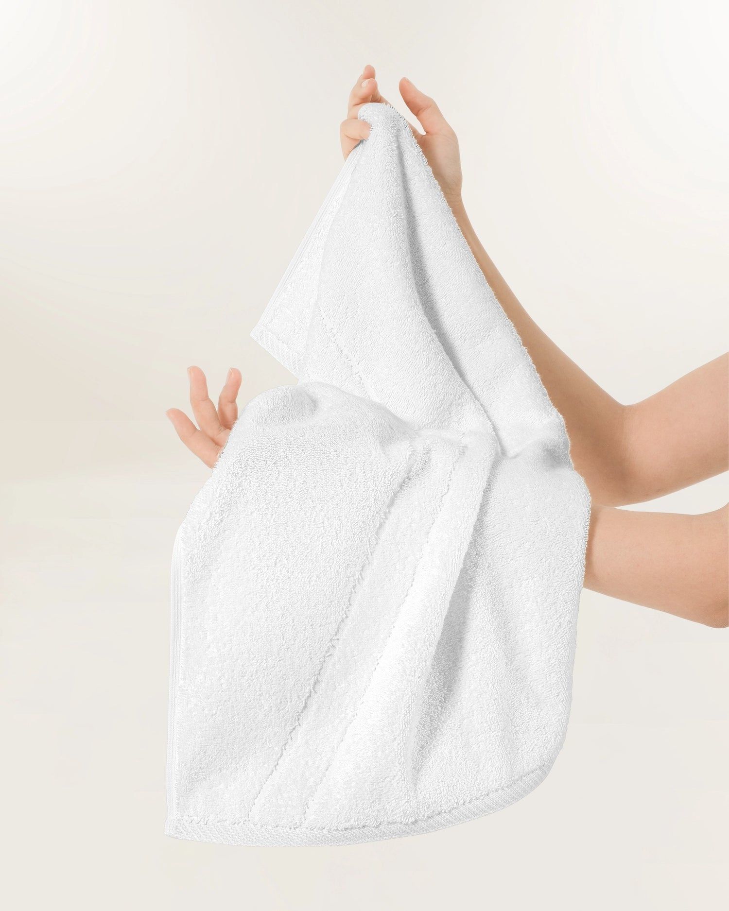 Hands holding a white towel or cloth against a plain light background