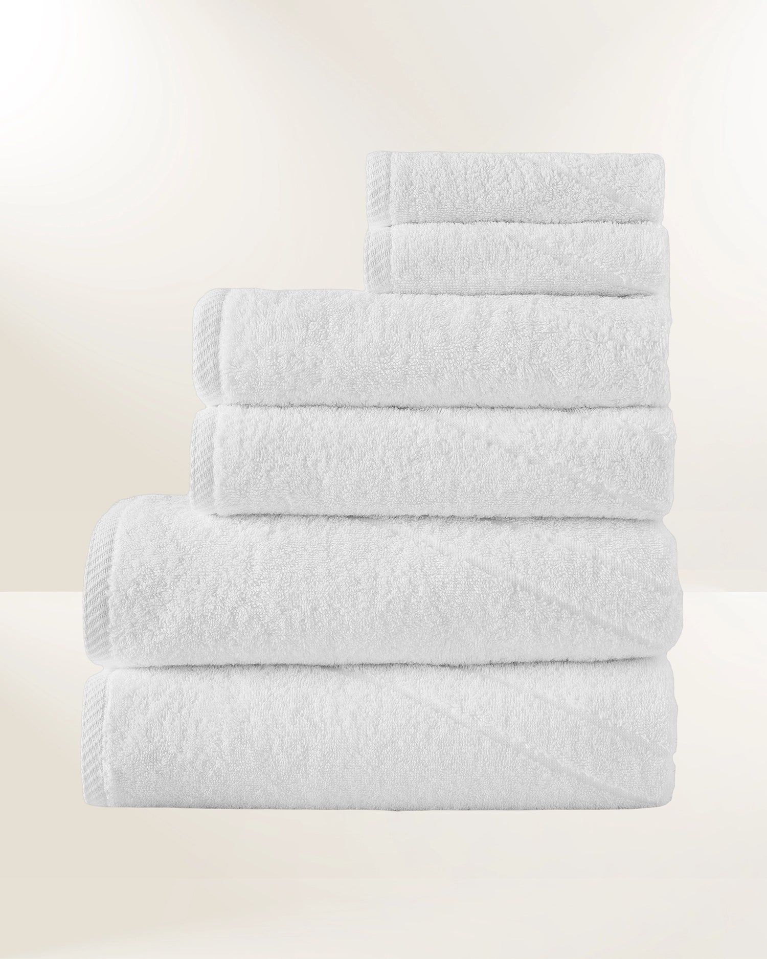 Stack of neatly folded white towels on a light background