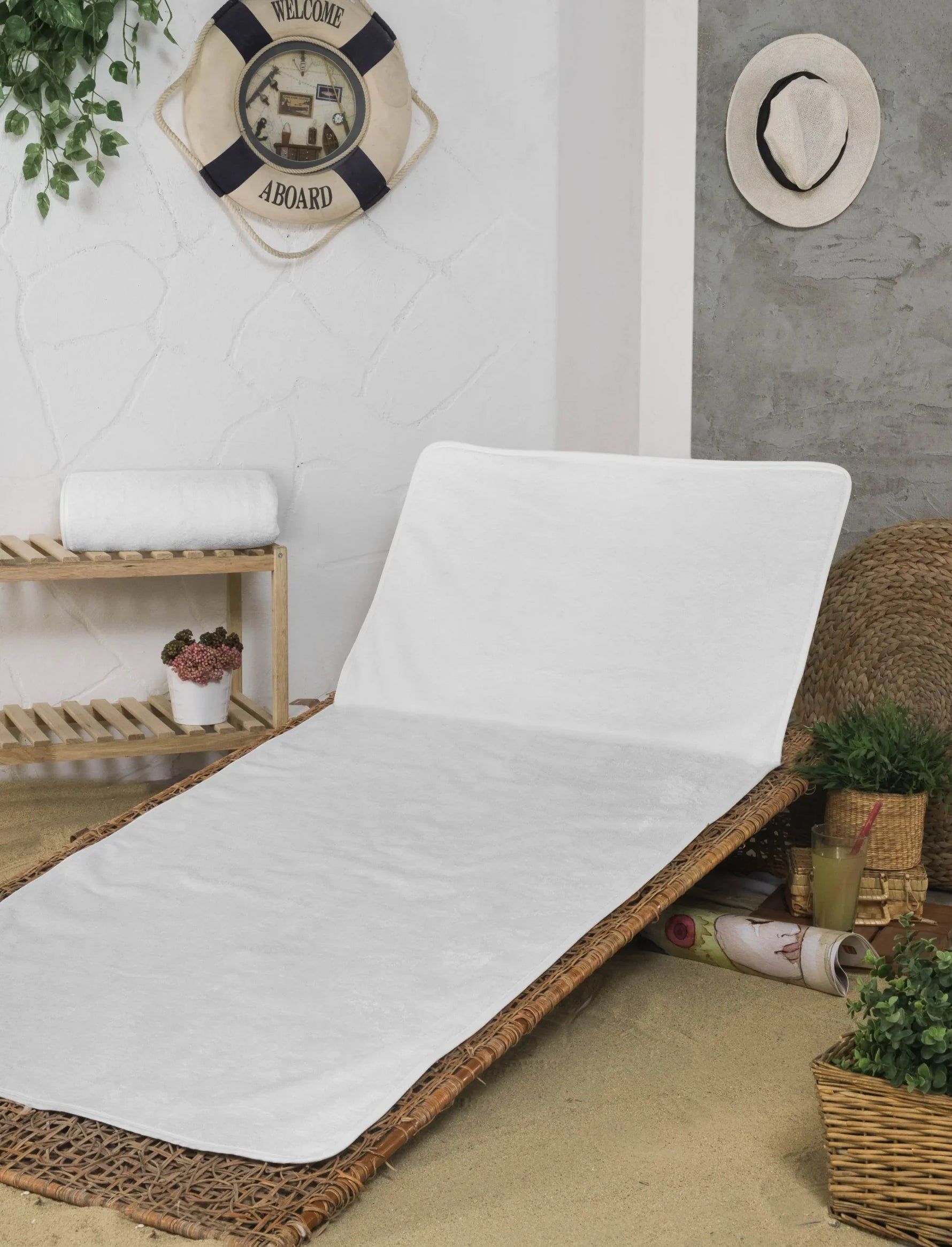 White cushioned lounge chair on a sandy patio with woven baskets and wall decor