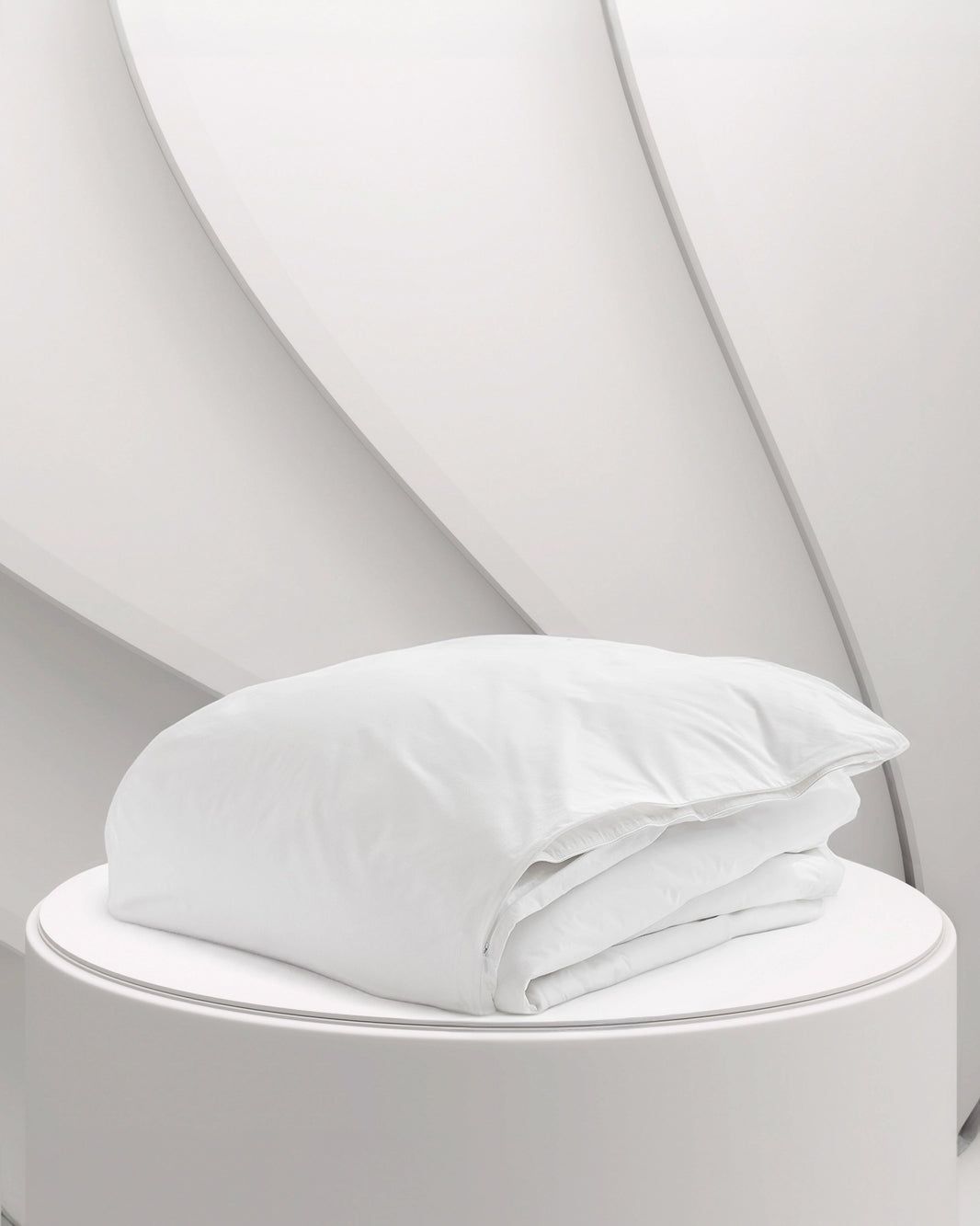 White folded towel on a round pedestal against a light gray abstract background.