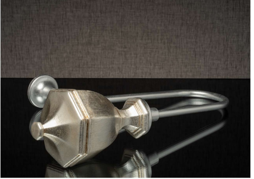 Metallic modern teapot with a sculpted, conical body and long handle on a reflective black surface