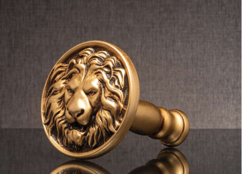 Gold lion-head doorknob on a dark textured background