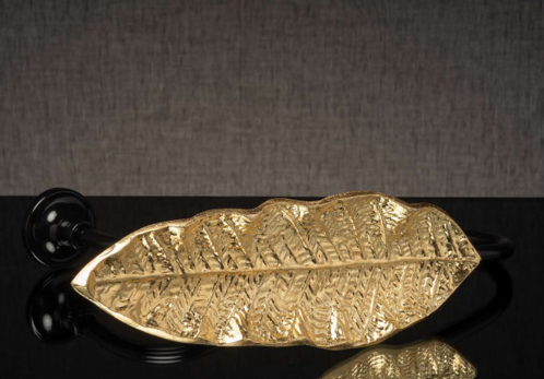 Gold leaf-shaped decorative object on a dark background