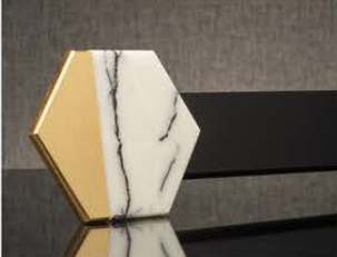 Hexagonal marble and gold decorative tile on a black reflective surface
